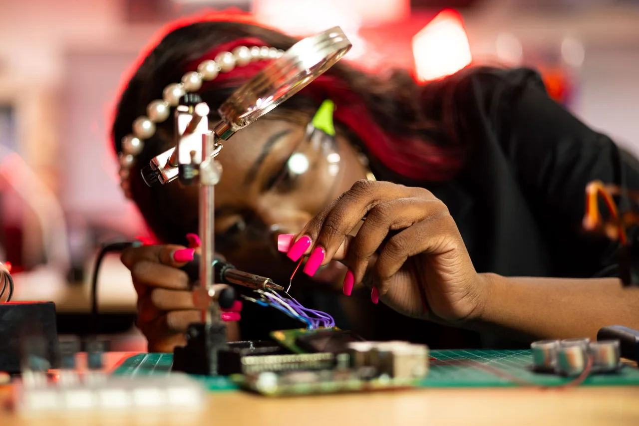 Engineer examining and repairing an electronic circuit board